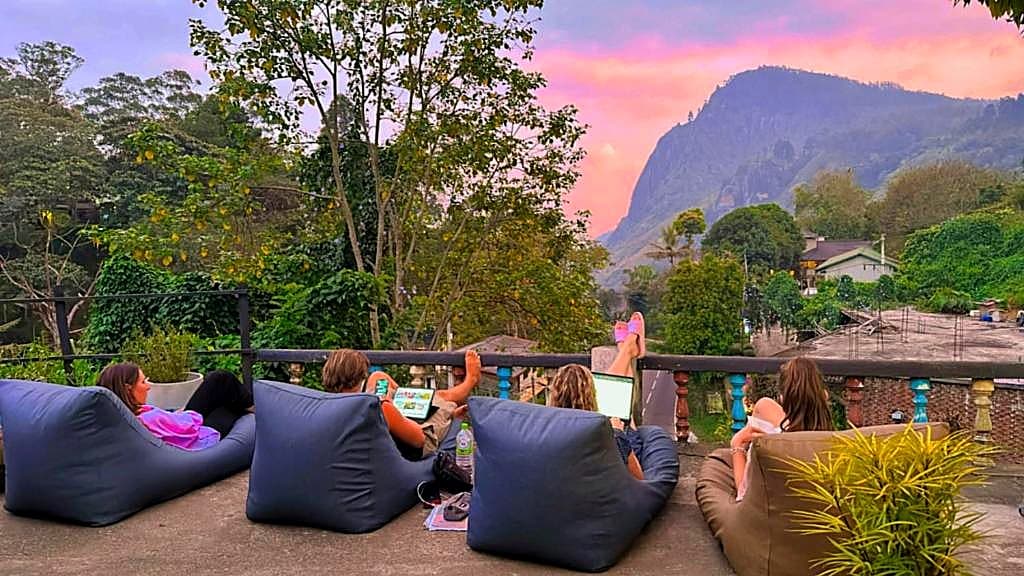 Guests relaxing on bean bags as the sun sets over Ella's peaks